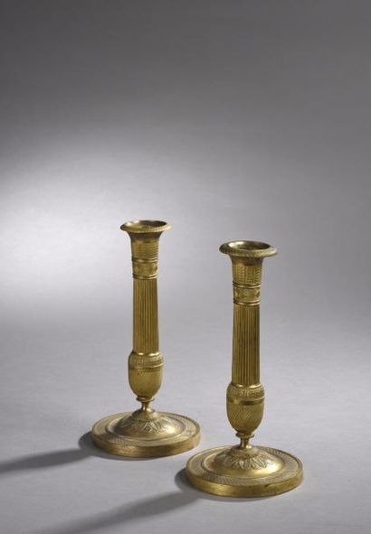 null PAIRE DE BOUGEOIRS en bronze ciselé et doré décoré à la molette. Fût en colonne...