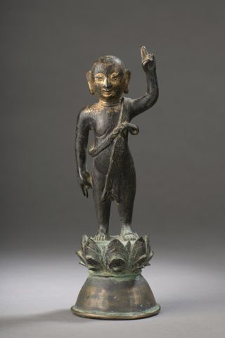 null STATUETTE en bronze anciennement doré figurant le Bouddha enfant, debout sur...