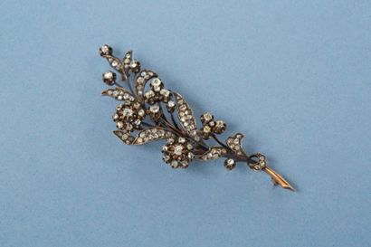 null Broche en or 14K 585‰, et argent 1er titre 950‰, représentant une branche fleurie,
sertie...