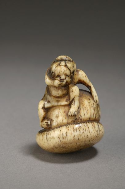 null Netsuke en corne de cerf figurant un enfant assis sur un champignon géant, la...