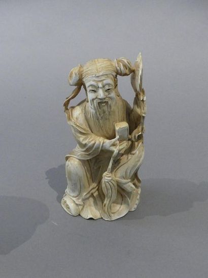 null Sujet en ivoire sculpté et rehaussé à l’encre, représentant un vieillard assis,...