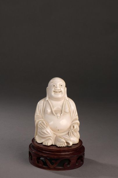 null Statuette en ivoire avec des rehauts d’encre, figurant Budai assis, souriant,...