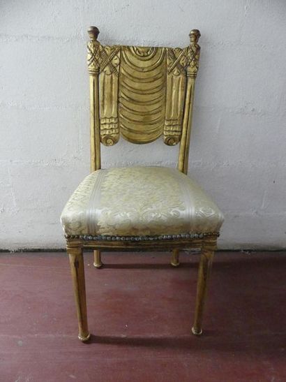 null Suite de sept chaises en bois doré, à dossier sculpté, décor de draperies.