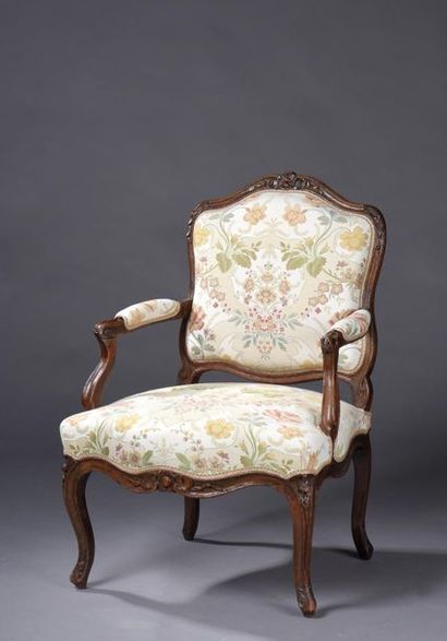 null FAUTEUIL à dossier plat en noyer mouluré et sculpté de fleurettes et cartouches....