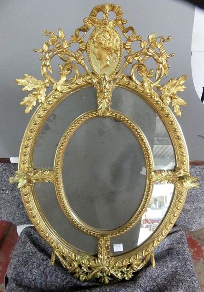 null Miroir ovale en bois doré orné d'un médaillon à profil de femme. 
Travail moderne,...