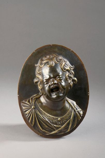  MEDAILLON en bronze à deux patines à décor en haut relief d’un buste d’enfant pleurant....