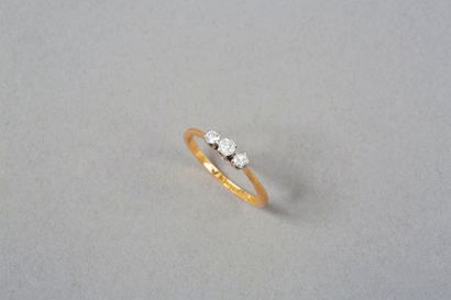 null Bague en or deux tons 18k 750‰, les griffes en platine, 900‰, serties de trois...