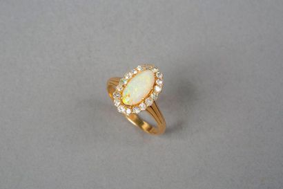 null Bague en or jaune 18k 750‰ de forme ovale sertie d'une opale dans un entourage...