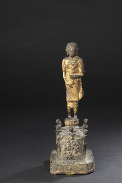null STATUETTE en bronze partiellement doré figurant le Bouddha debout, les yeux...
