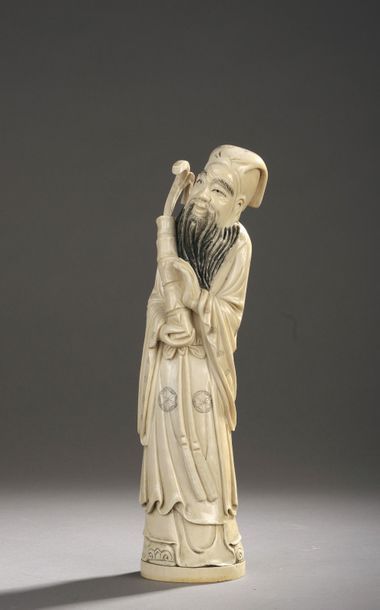 null Okimono en ivoire sculpté et rehaussé à l’encre figurant un lettré taoïste debout,...