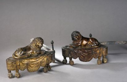 null PAIRE DE CHENETS en bronze doré ornés de lions couchés, pattes antérieures croisées,...