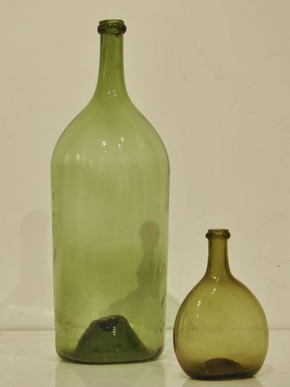 null Deux bouteilles en verre soufflé à teinte verte. L'une à panse globulaire, l'autre...