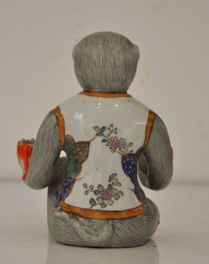 null Bougeoir en porcelaine polychrome représentant un singe assis portant des fleurs...