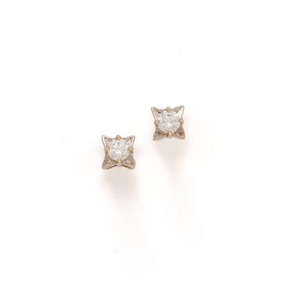 null A pair of 18K (750/1000) two-tone gold earrings with an etile motif set with...