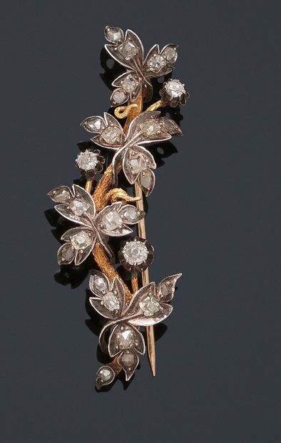 null 18K (750/1000) yellow gold and silver (800/1000) brooch decorated with a branch...