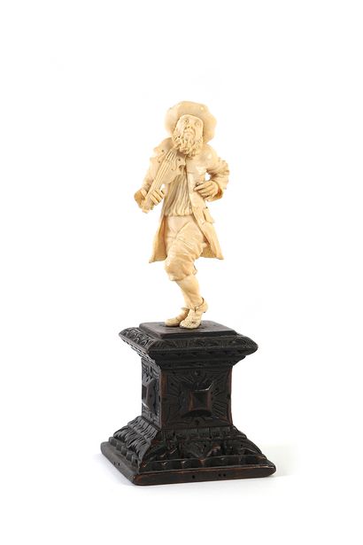 A bowed hurdy-gurdy player in ivory carved...