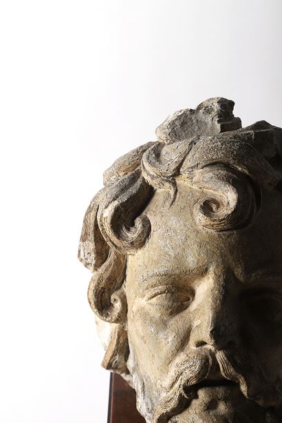 null Carved limestone head of a man. Hair elaborated into a hairstyle with a parting...