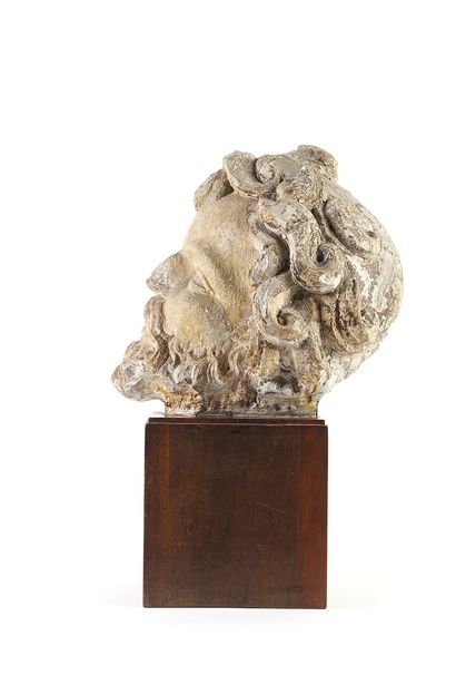 null Carved limestone head of a man. Hair elaborated into a hairstyle with a parting...