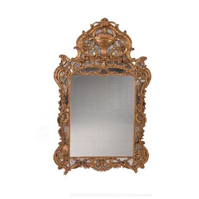 Un miroir en bois doré à décor ajouré de...