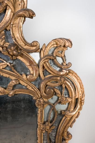  Un miroir en bois doré à décor ajouré de nœuds de ruban, vases néoclassique, feuillages,...