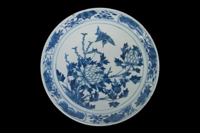  CHINE - Vers 1900 Grand plat en porcelaine décorée en bleu sous couverte d’un martin...