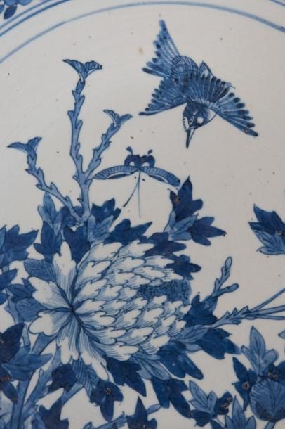  CHINE - Vers 1900 Grand plat en porcelaine décorée en bleu sous couverte d’un martin...