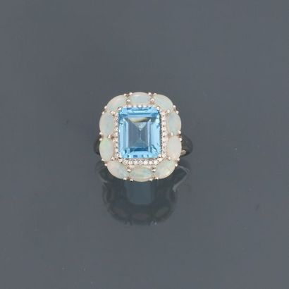 null White gold ring, 750 MM, centred on a blue emerald cut topaz hemmed with diamonds...
