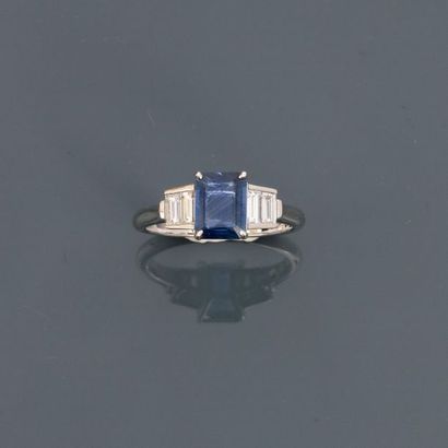 null White gold ring, 750 MM, adorned with an emerald-cut sapphire cut with cut sides...