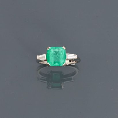 null White gold ring, 750 MM, decorated with an emerald cut emerald with cut steps...
