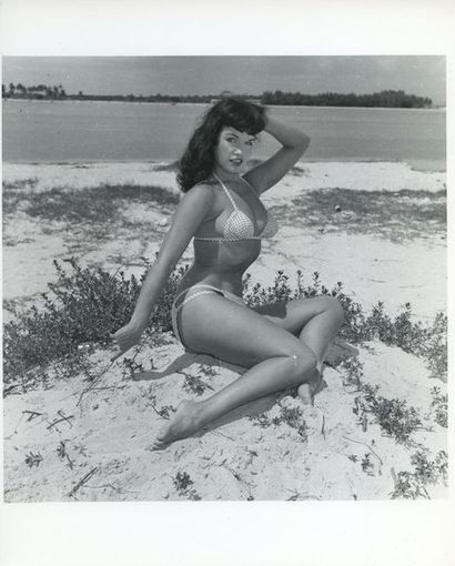 null Bunny YEAGER (1929-2014). Betty Page, sur le sable, en bikini blanc à poix noirs....
