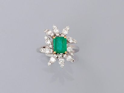 null Ring in white gold, 750 MM, centered by an emerald cut emerald surrounded by...