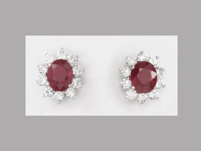 null White gold earrings, 750 MM, each centred on a treated oval ruby, total about...