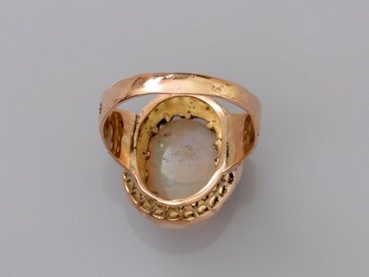 null Yellow gold ring, 750 MM, decorated with a cabochon opal in a row of rose cut...