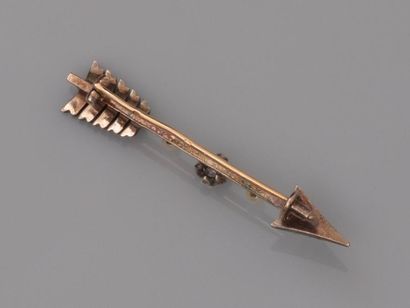 null Brooch drawing an arrow in yellow gold, 750 MM, centered on a diamond decorated...