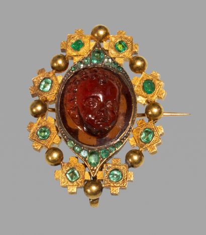 null A gold holbeinesque brooch, set with a carved glass imitating carnelian with...