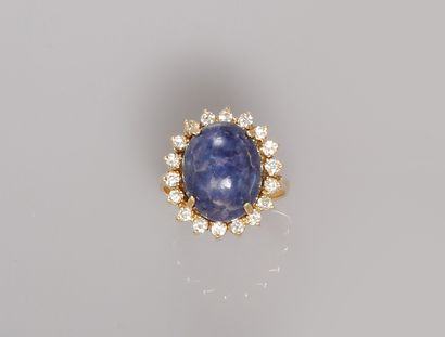 null Yellow gold ring, 750 MM, centered on a lapis lazuli cabochon hemmed with diamonds,...