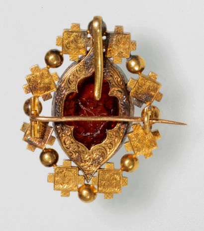 null A gold holbeinesque brooch, set with a carved glass imitating carnelian with...
