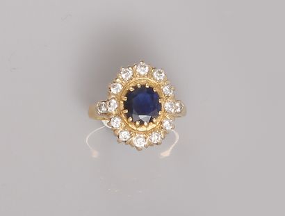  Yellow gold ring, 750 MM, centered on an oval sapphire in a row of diamonds between...