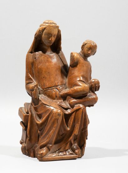 null Vierge à l’Enfant en buis sculpté en ronde-bosse. Assise sur un banc, Marie...