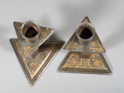 null Rare paire de bougeoirs en fer damasquiné d’or.

La base triangulaire reçoit...