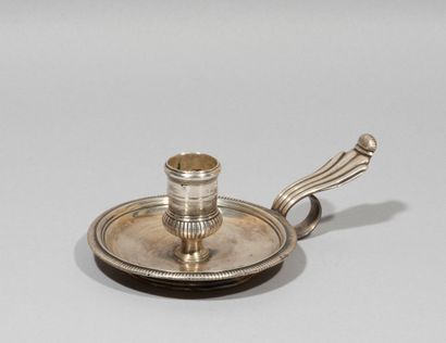 null Candlestick with hand out of silver.

Of circular shape with gadrooned edges,...