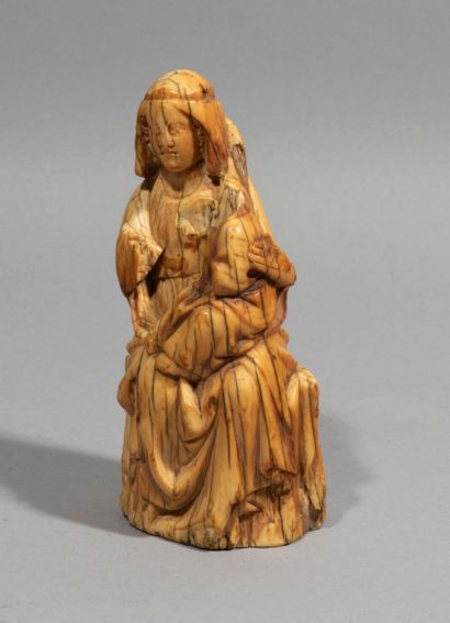 null Vierge à l’Enfant en ivoire sculpté en rondebosse. Assise, Marie tient son Fils...