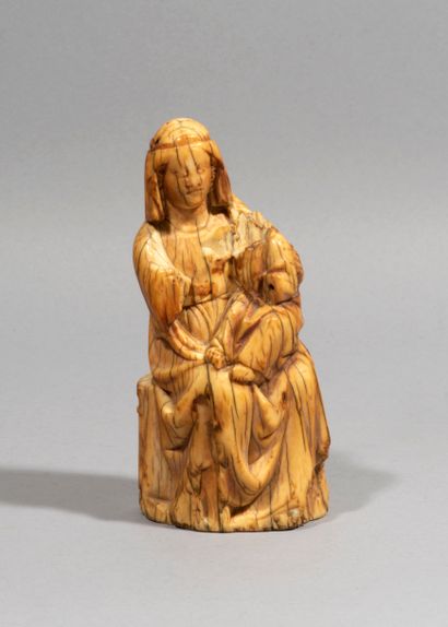 null Vierge à l’Enfant en ivoire sculpté en rondebosse. Assise, Marie tient son Fils...