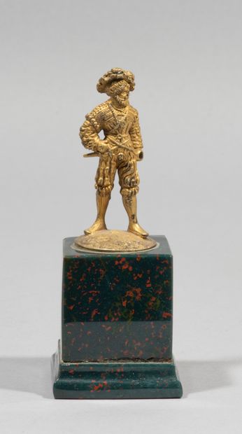 null Lansquenet in gilt bronze, naturalist base. Wearing a feathered hat

hat, he...