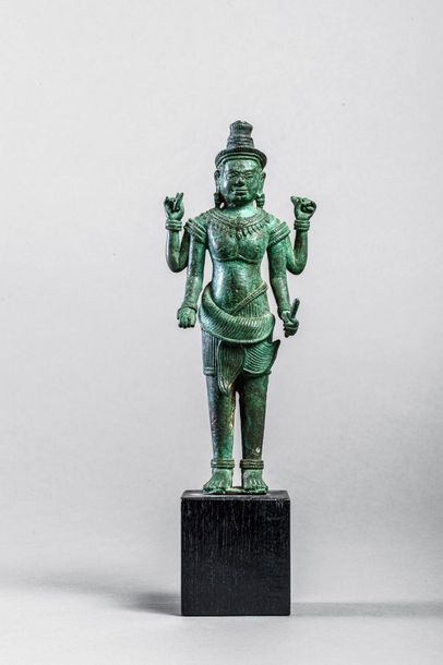 null Vishnu debout dans une posture hiératique sous une forme à quatre bras tenant...