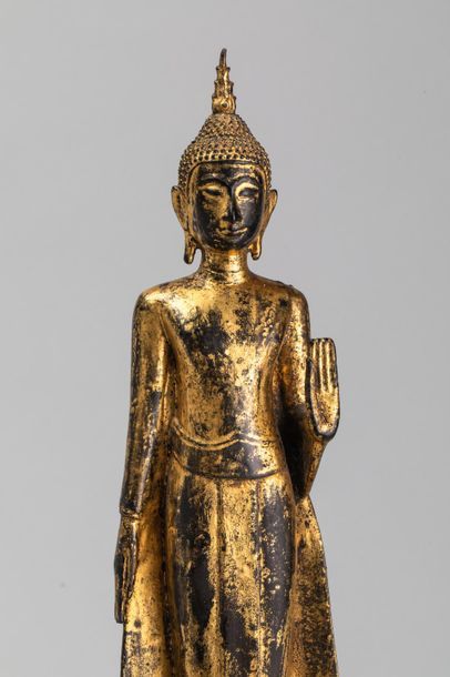 null Buddha debout sur un haut socle lotiforme déployant sa robe monastique de sa...