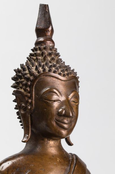 null Buddha Maravijaya assis sur un haut socle étagé, coiffé de bouclettes hérissées...