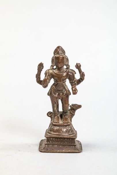 null Shiva Bhaïrava, debout sur un haut piédestal sous une forme à quatre bras tenant...