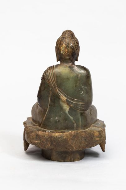 null Buddha assis sur une base couverte du textile drapé de sa robe monastique retombant...