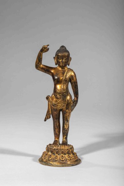 null L’enfant Buddha figuré debout sur une base loti forme circulaire. Bronze doré....